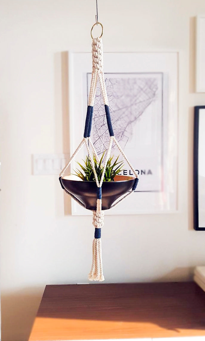 Macrame Plant Hanger handcrafted in 100% Ontario cotton rope with navy accents, suspending a black bowl planter.