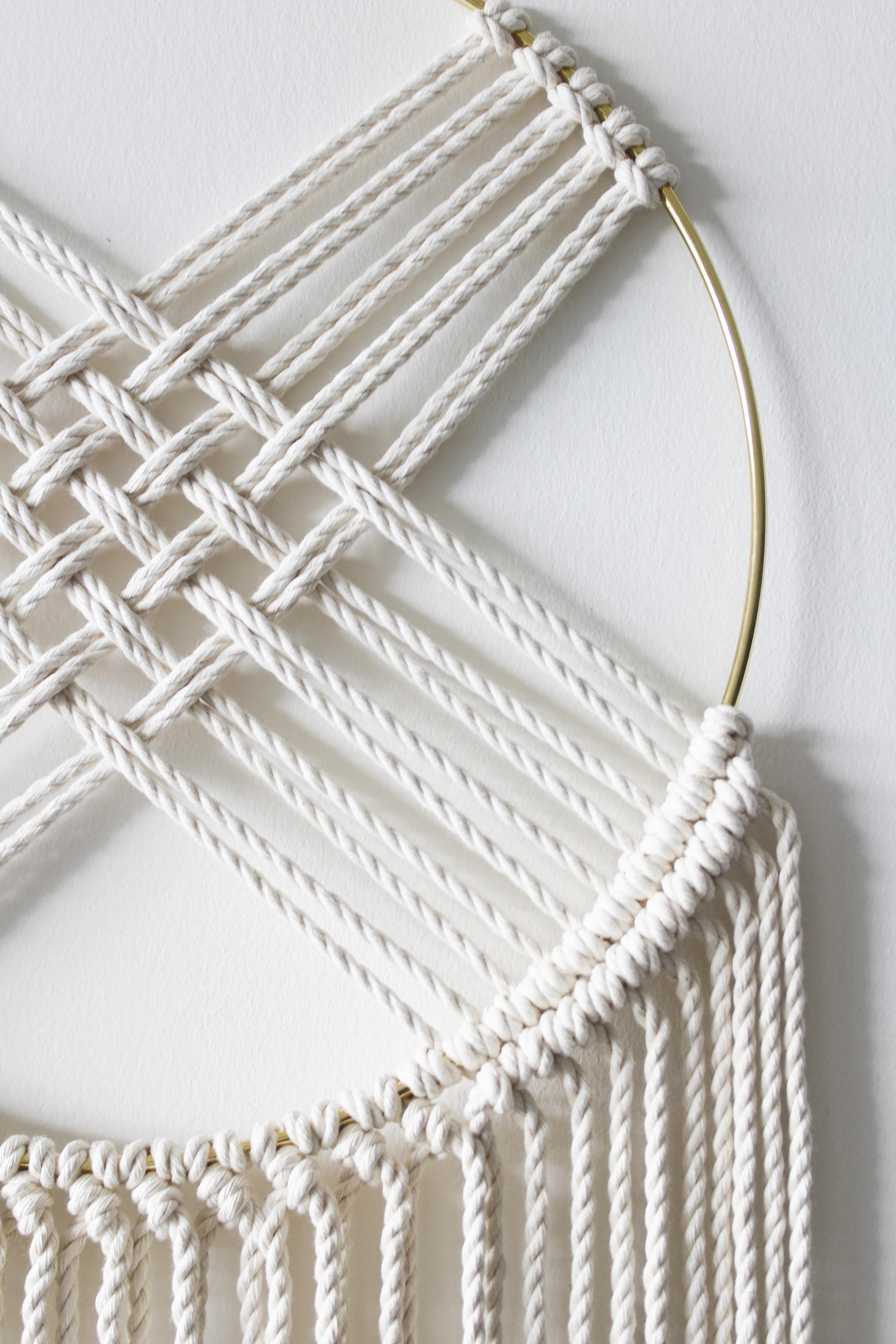 Macrame dreamcatcher wall hanging with gilded brass hoop and long knotted fringe