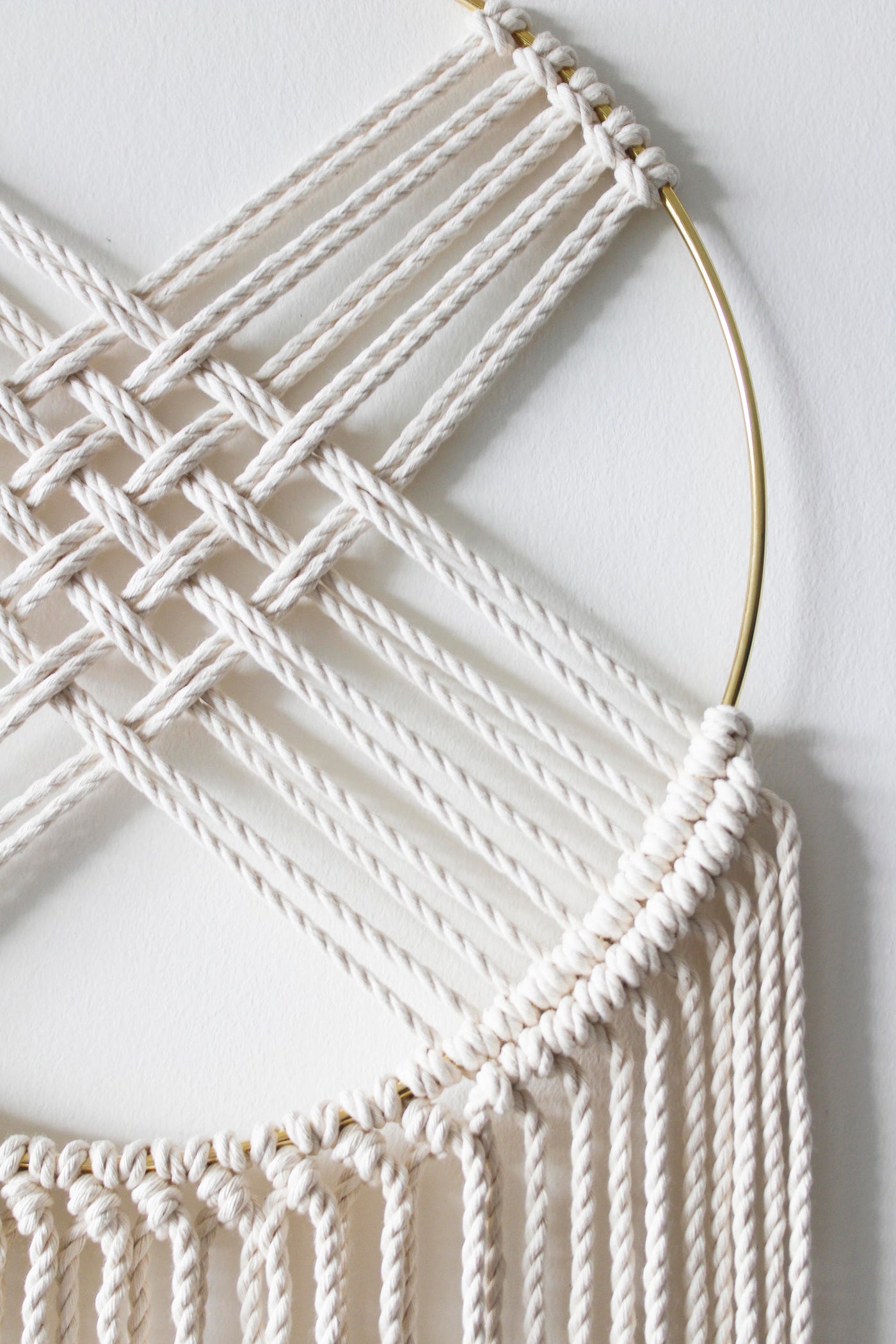 Macrame dreamcatcher wall hanging with gilded brass hoop and long knotted fringe