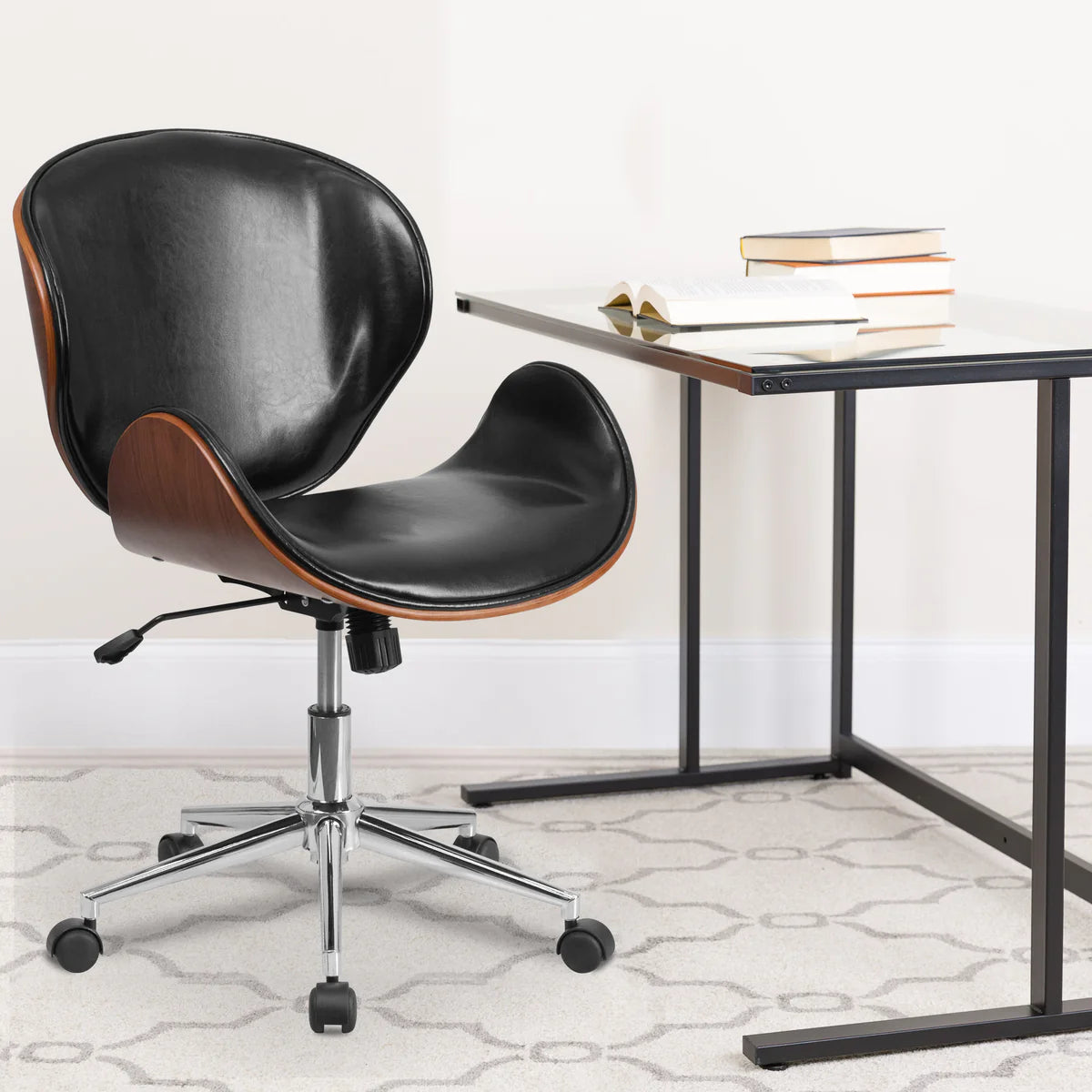 Mid-back walnut bentwood office chair with black leather and curved design beside a glass desk.