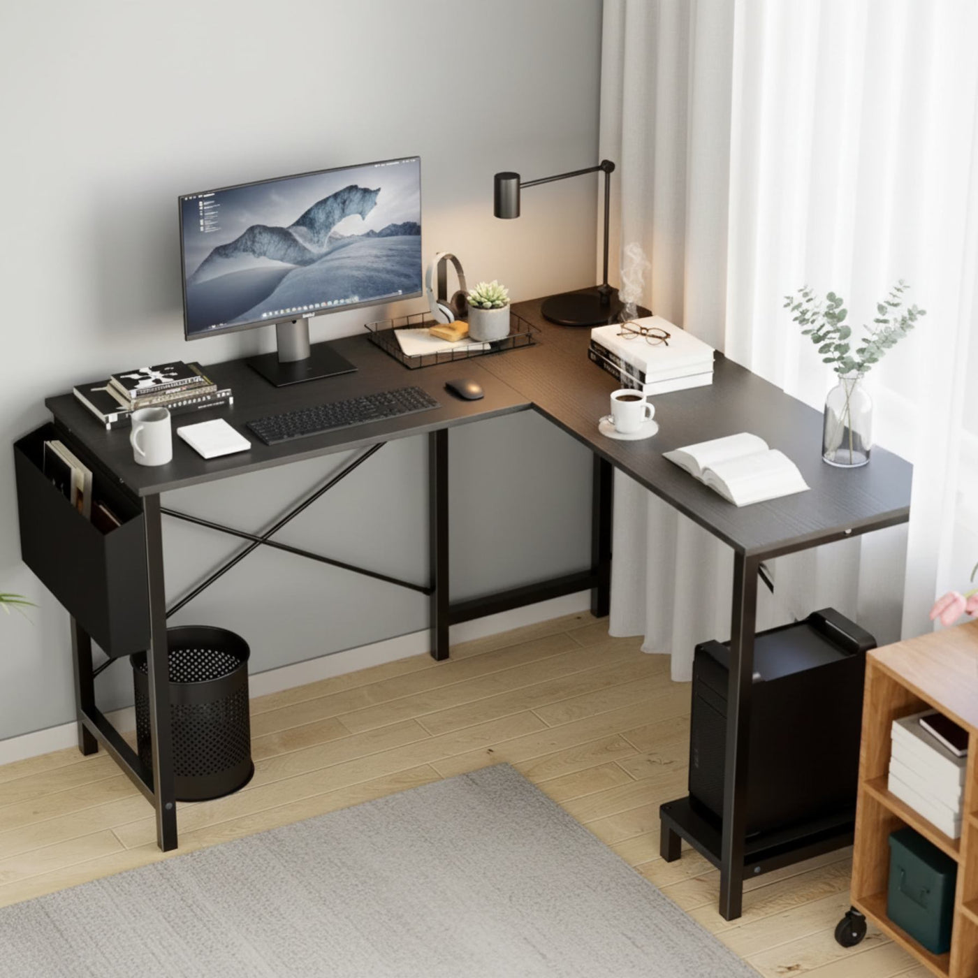 Modern home office with a black L-shaped desk, computer setup, and decor.