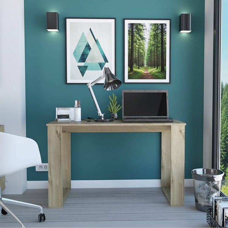 Modern home office with a wooden desk, laptop, lamp, and wall art.