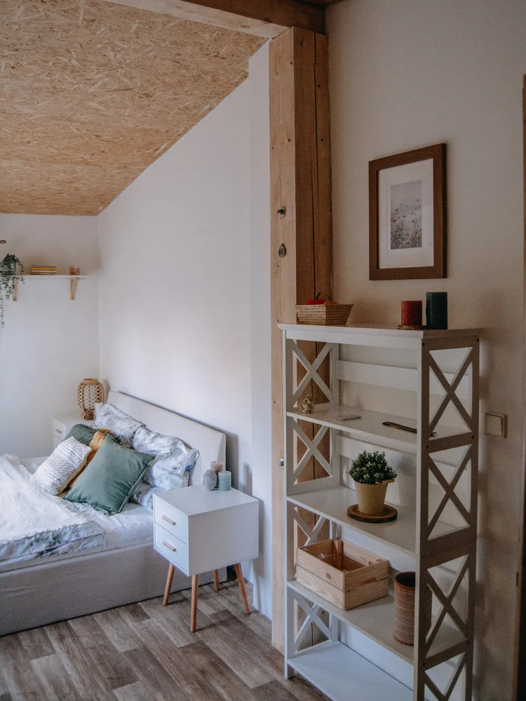 White piano-finish 2-drawer end table/nightstand beside bed in a modern, minimalist bedroom.