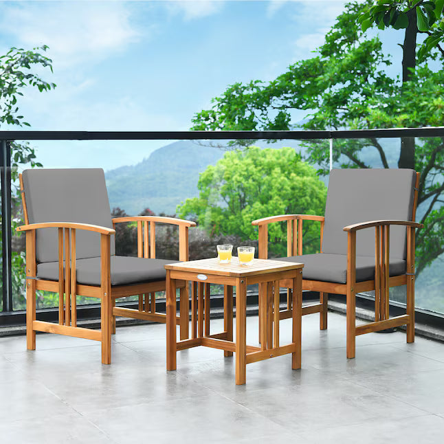 Outdoor furniture set with two chairs and a small table on a balcony with a scenic view.