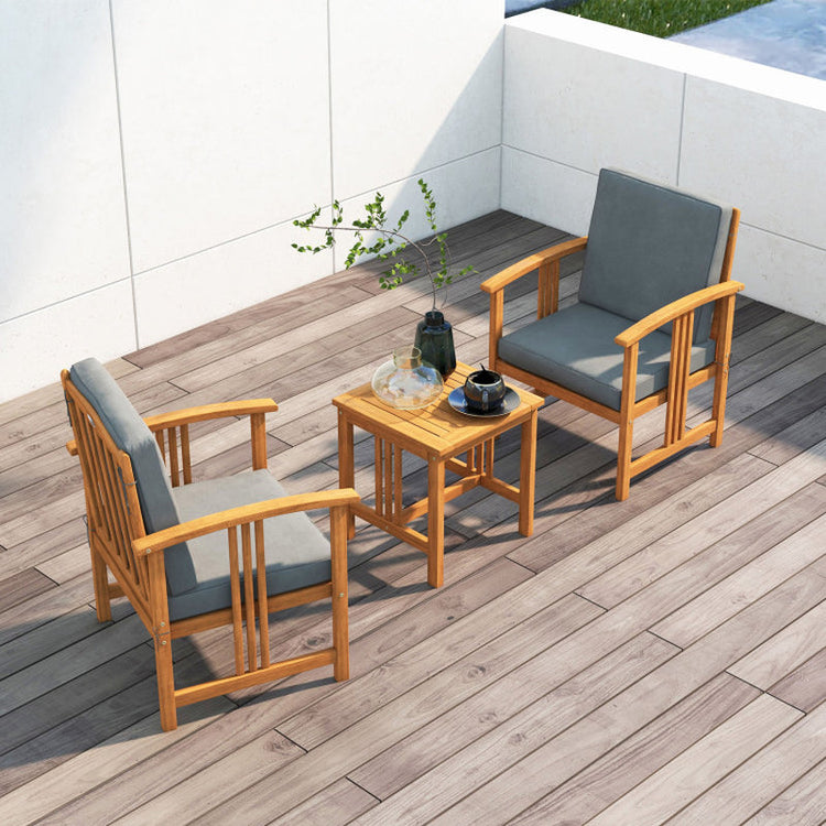 Outdoor furniture set with wooden chairs and table on a wooden deck.