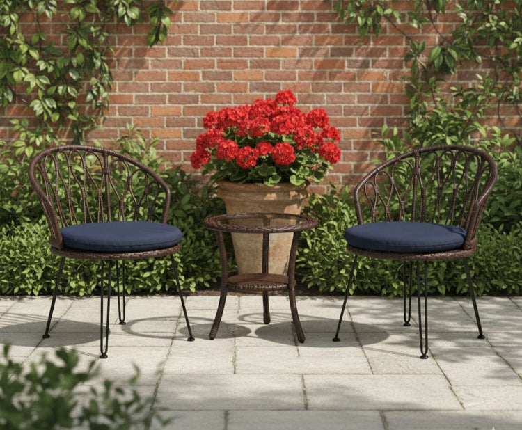 Outdoor patio set with two chairs and a table in front of a brick wall with greenery.
