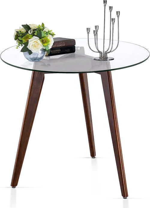 Round glass dining table with 8mm beveled edge on warm oak tripod legs in mid-century style.