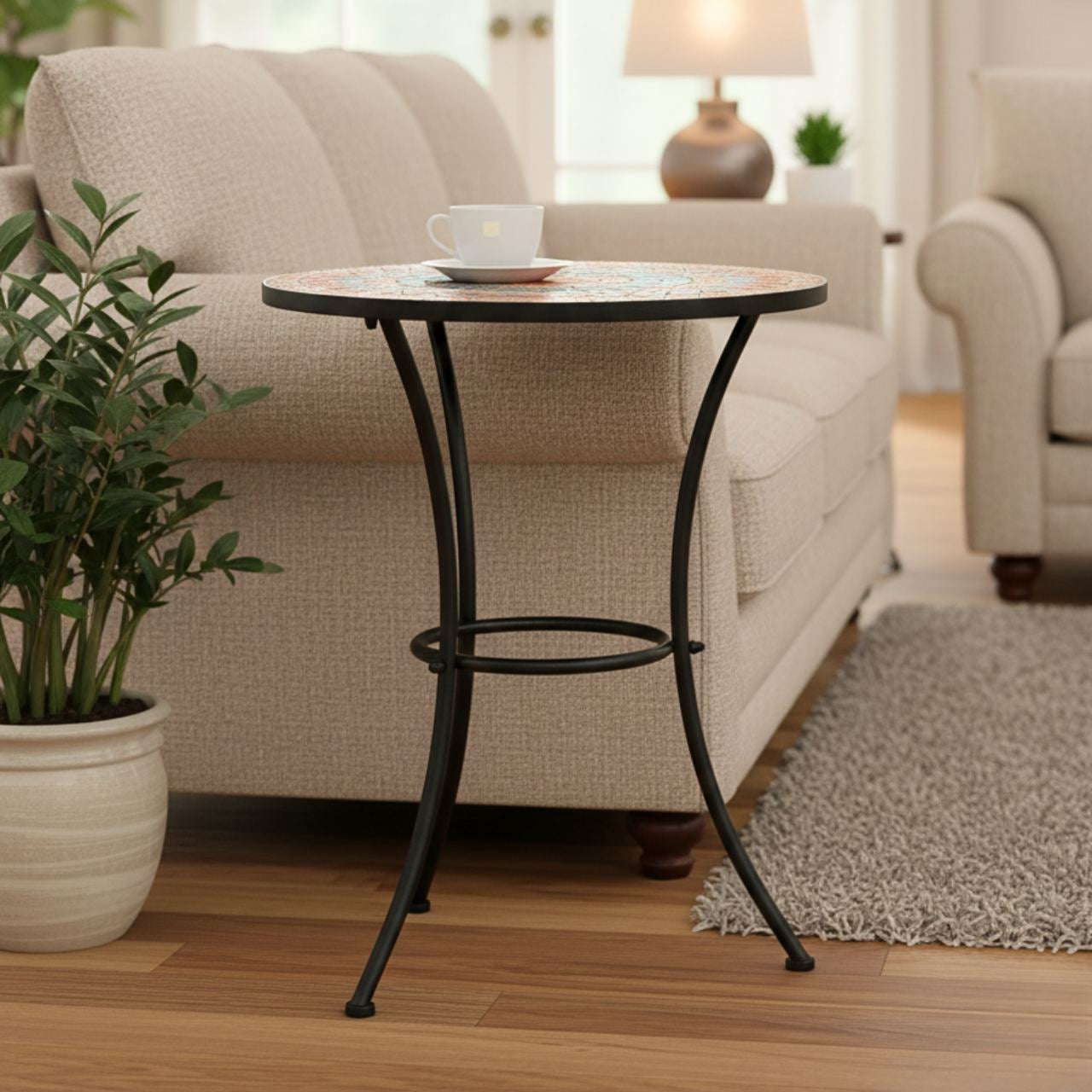 Round mosaic table with grey and orange tiles on a black metal base, compact for small balconies.