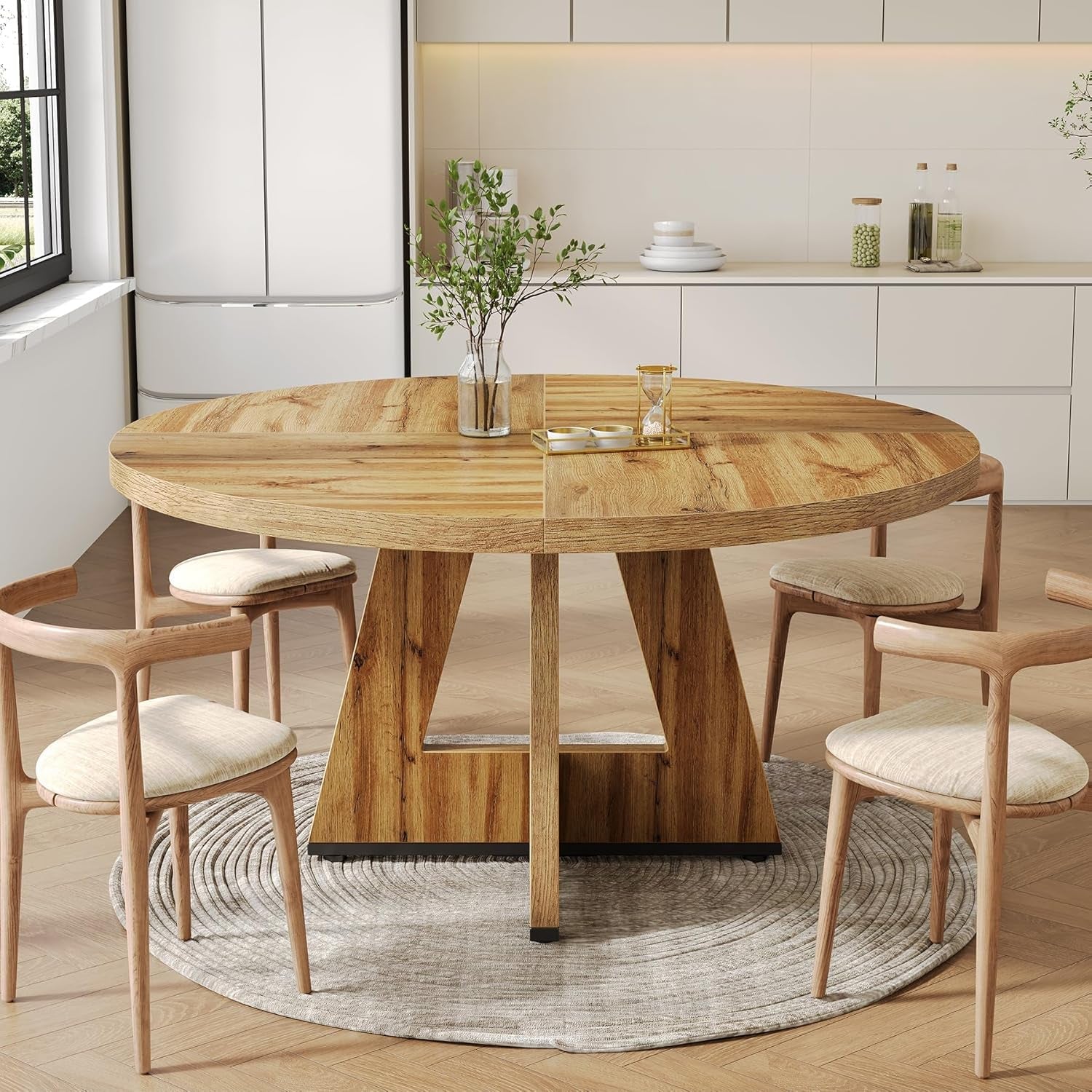 Round wooden dining table with chairs in a modern kitchen setting