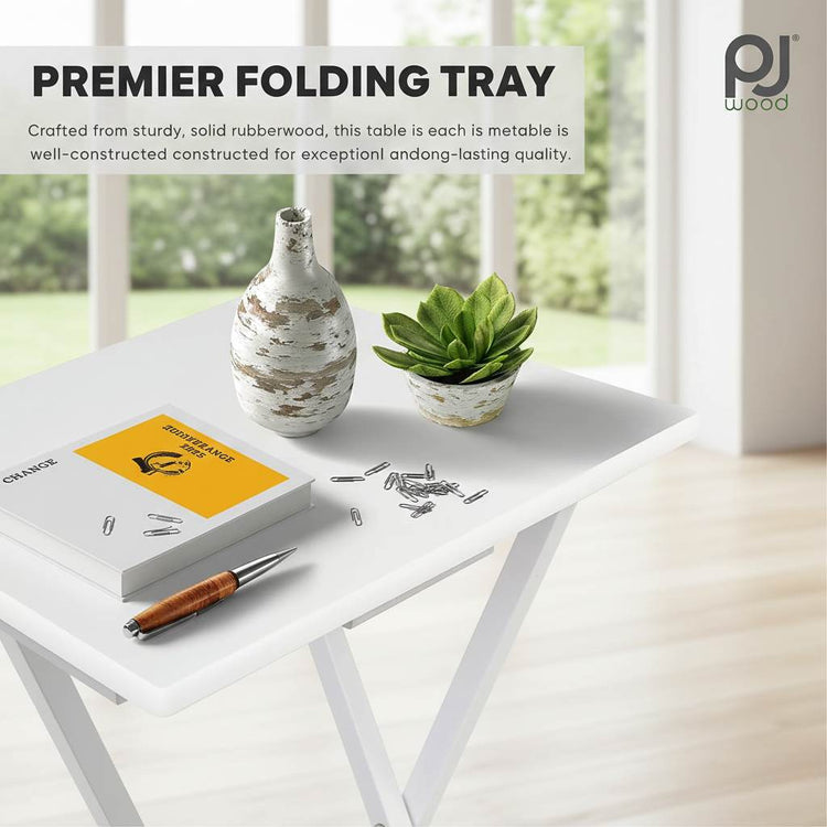 Set of 2 white wood-finish folding TV trays on a white table with plant and notebook.