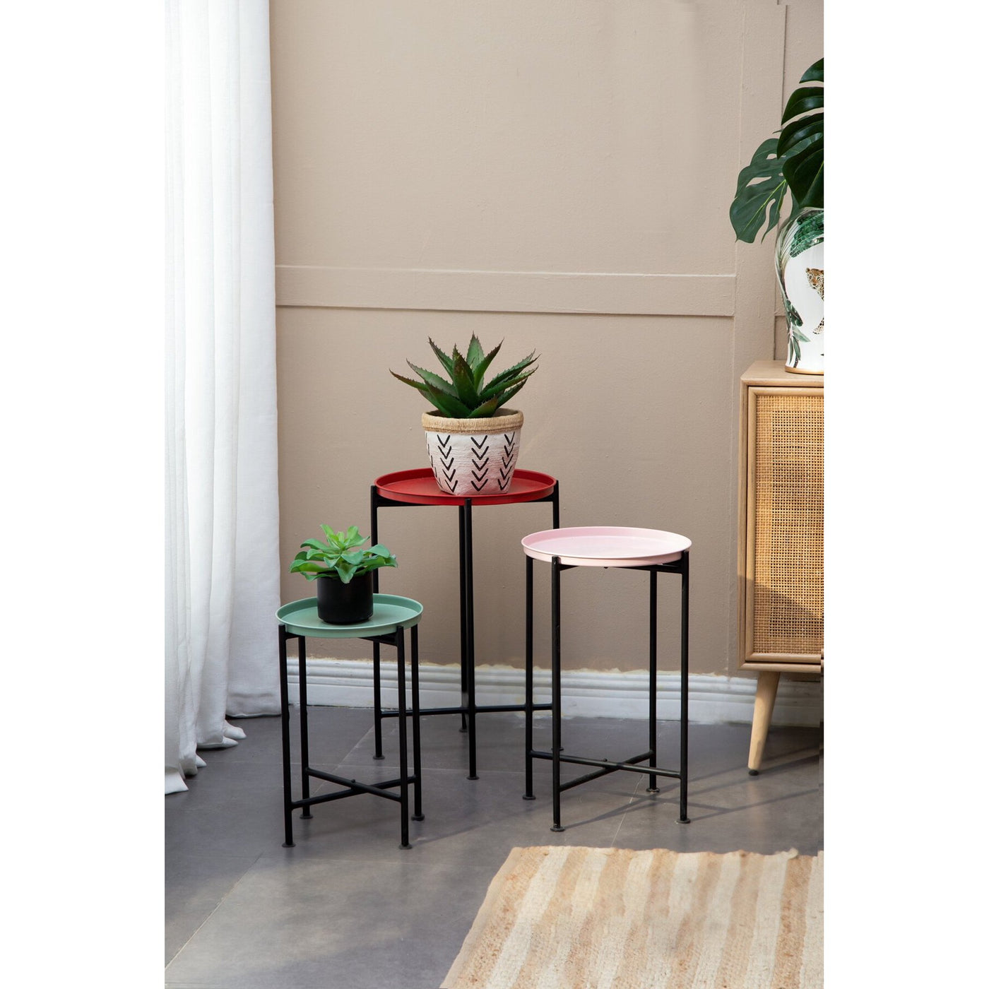 Set of small round tables with planters on a neutral background