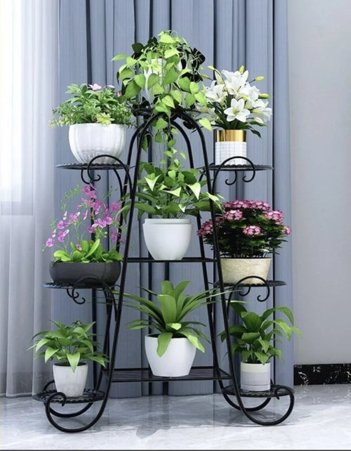 Six-layer black metal plant rack with multiple potted plants on a space-saving stand.