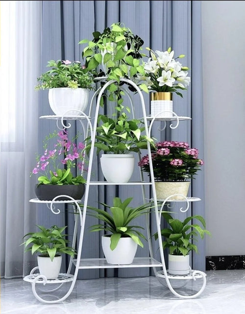 Six-tier white metal plant rack with multiple potted plants, space-saving vertical display for indoor greenery.