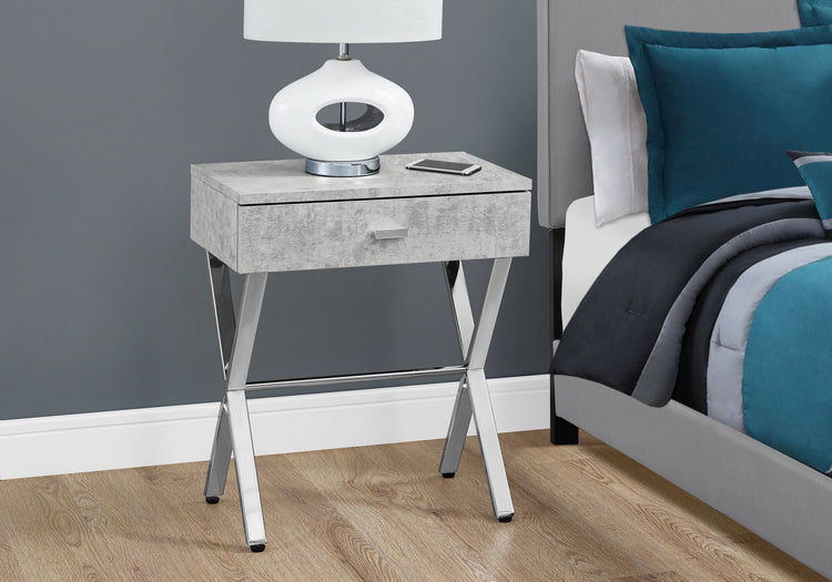 Sleek dark taupe finish accent table with chrome metal legs and a drawer beside a bed.