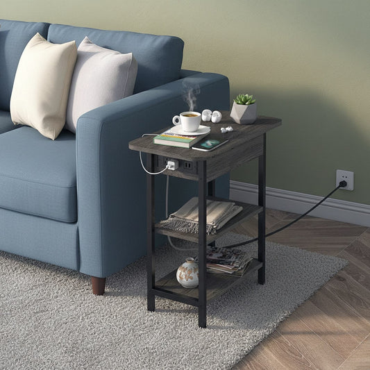 Small black side table next to a blue sofa with a cup, books, and a plant on it.