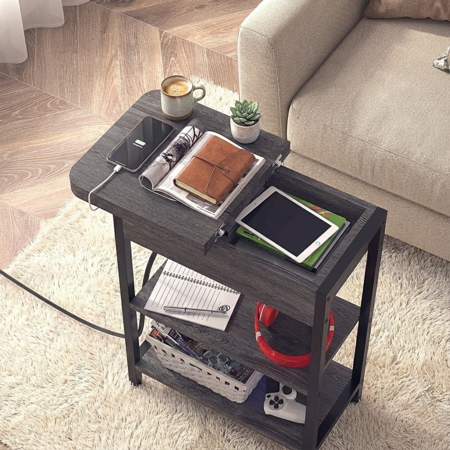 Small dark wood side table with various items on a light wooden floor.