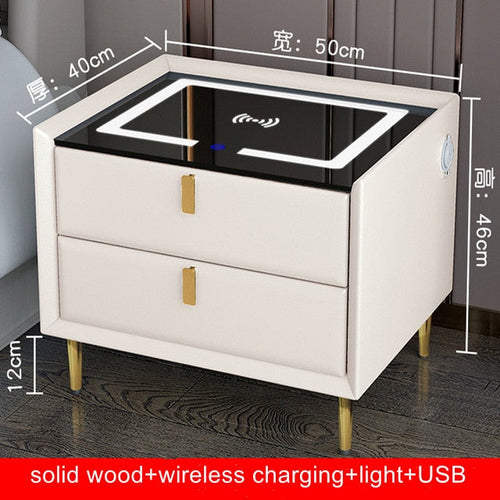 Smart bedside table with wireless charging pad, USB ports, two drawers, white finish, gold legs, ambient night light.