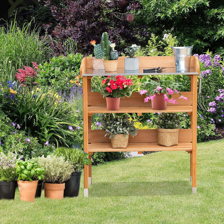 Solid wood outdoor garden bench table with bottom storage shelves and metal top, shown with potted plants.
