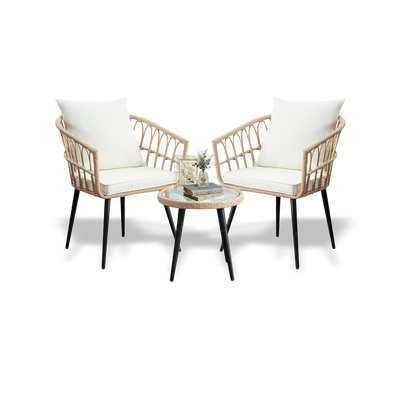 Two wicker chairs with white cushions and a matching table on a white background