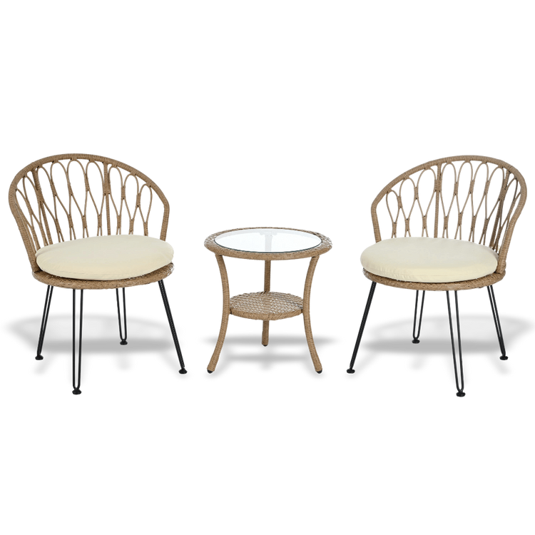 Two wicker chairs with cream cushions and a matching side table on a white background