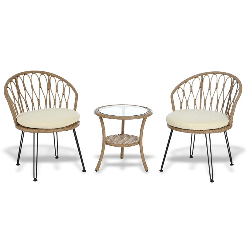 Two wicker chairs with cream cushions and a matching side table on a white background