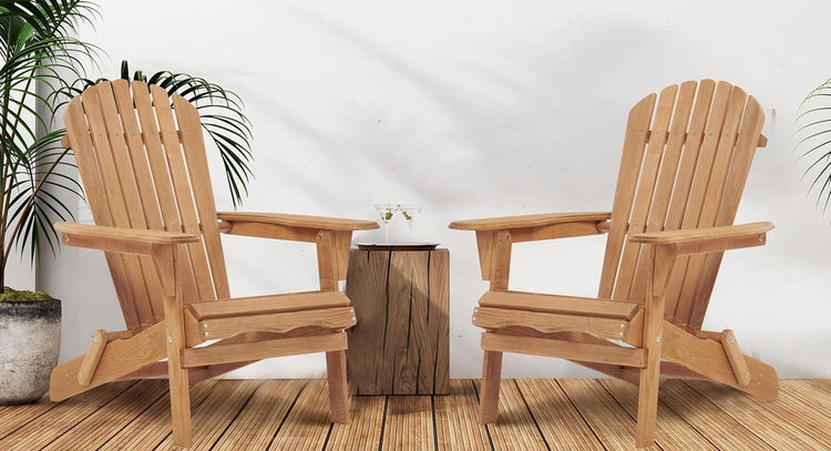 Two wooden Adirondack chairs on a wooden deck with a white wall background.