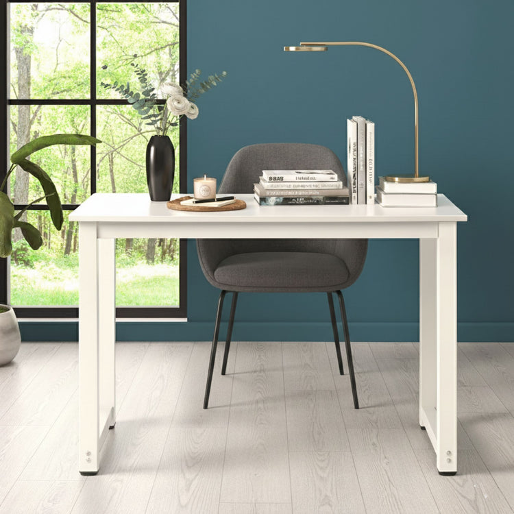 White desk with gray chair against a blue wall with a window view