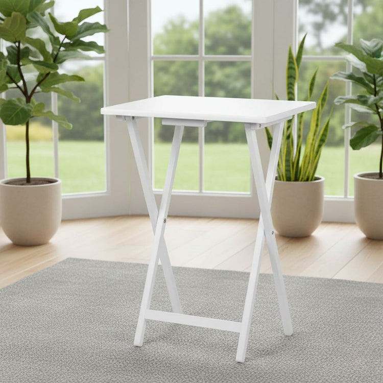 White wood-finish folding TV tray table on a rug in a bright living room