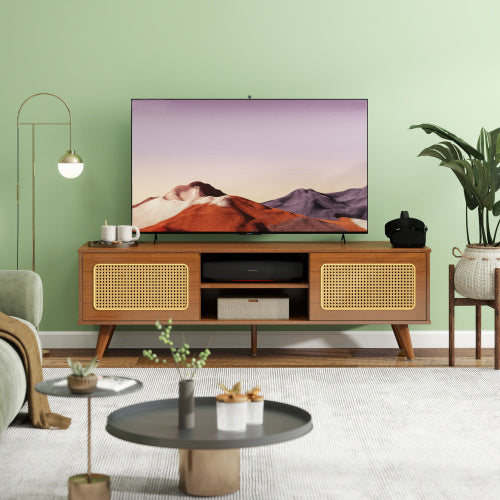Wooden TV stand with a television displaying a scenic image, surrounded by decorative items in a living room.