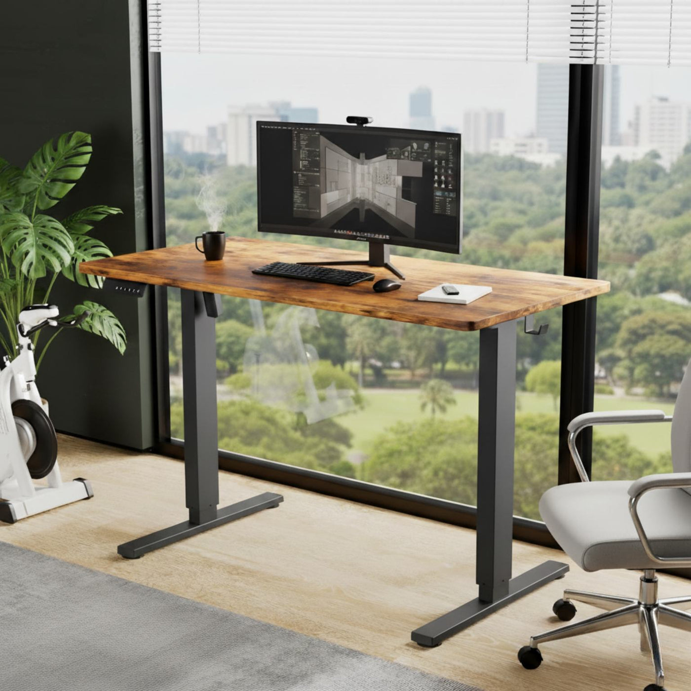 Wooden desk with computer setup in a modern office with large windows.