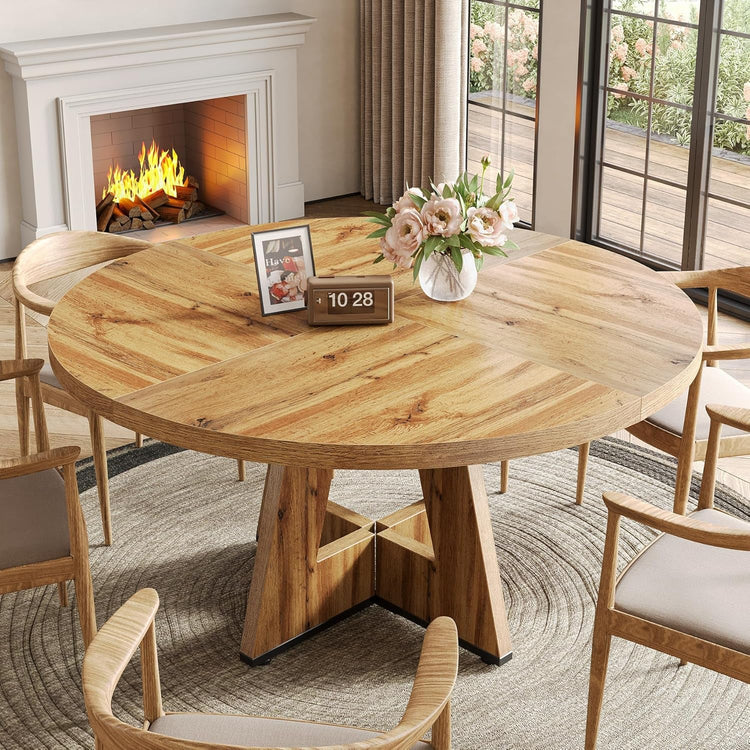 Wooden dining table with chairs in a cozy living room with a fireplace.