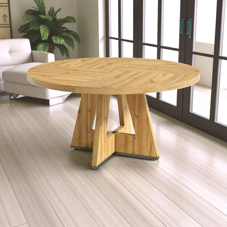 Wooden dining table in a room with a couch and large windows.