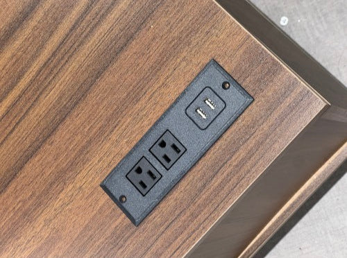 Wooden surface with a built-in electrical outlet panel.