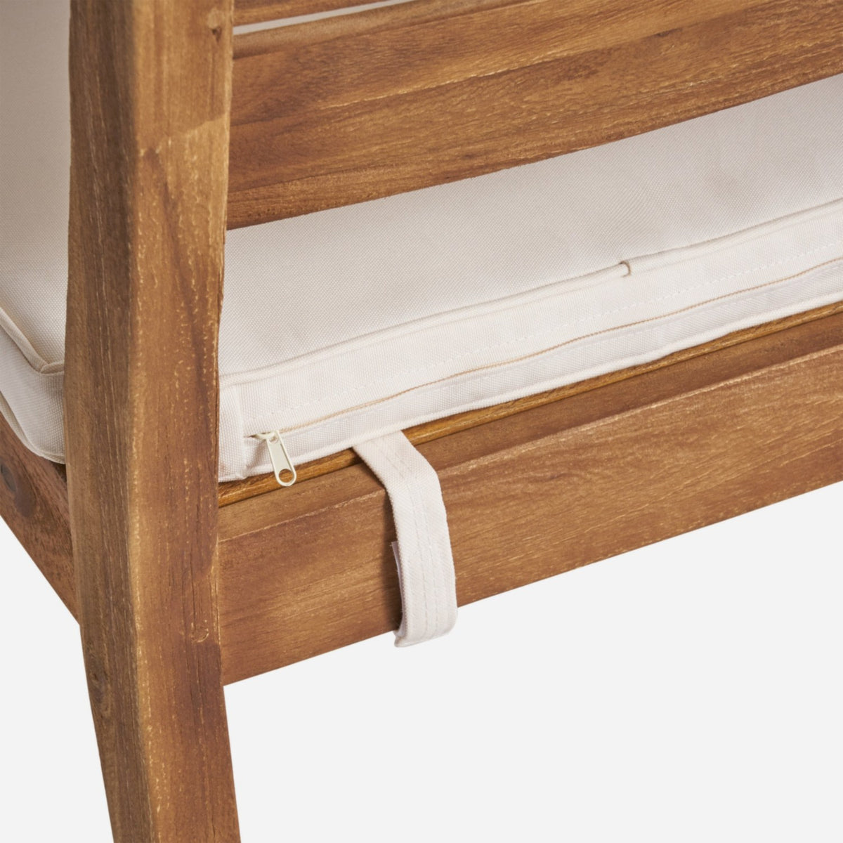 Side zip and fabric tie strap on a cream seat cushion resting on a wood seat apron (close-up detail)