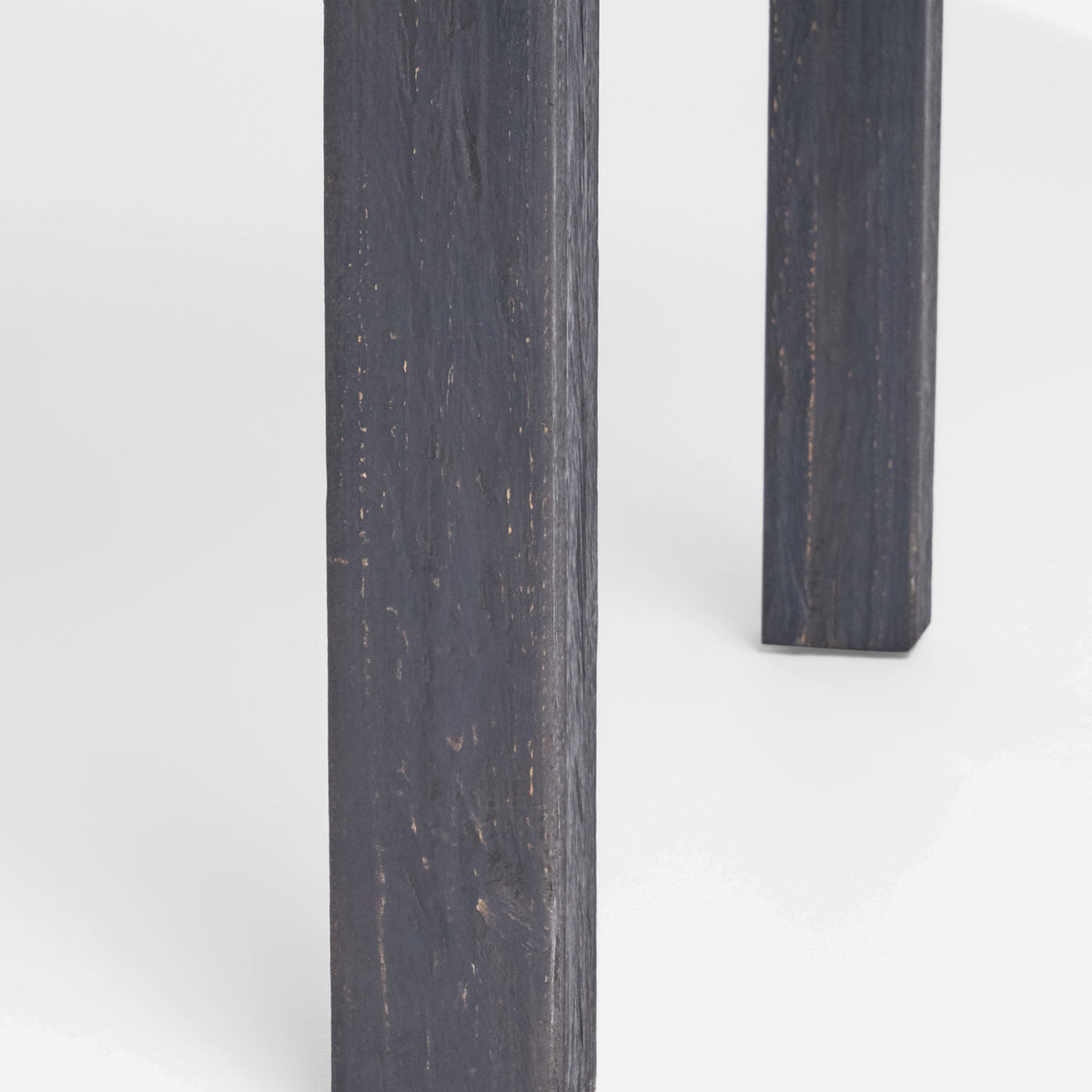 Square tapered chair leg in a dark gray sandblasted finish with visible grain (close-up detail)