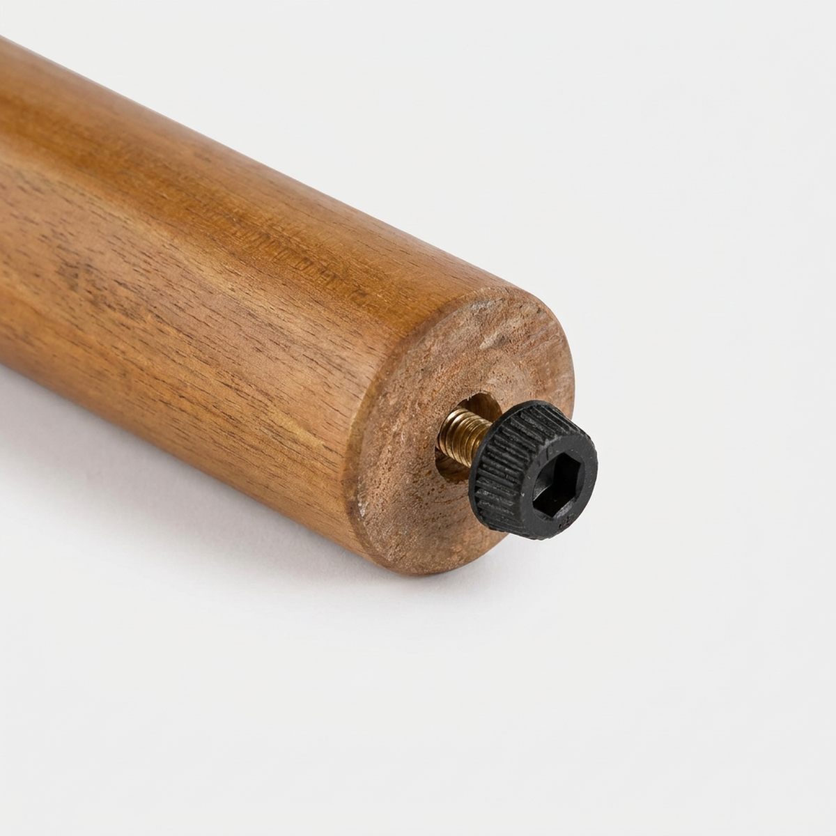 Close-up of the black bolt that fixes a tapered acacia leg to the frame rail