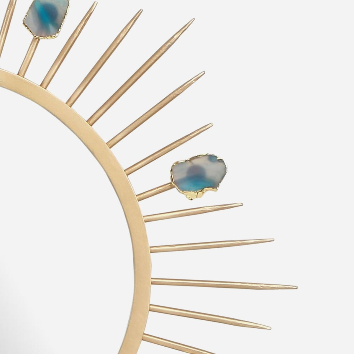 Close-up of tapered gold rays and a teal agate slice with a gold edge