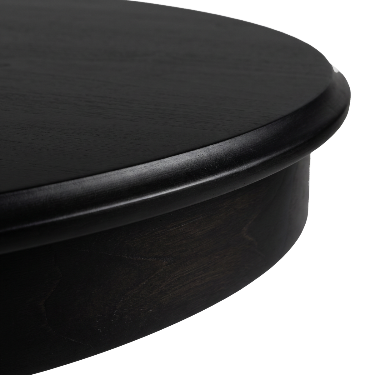 Molded top edge above the apron of a black desk (close-up detail)