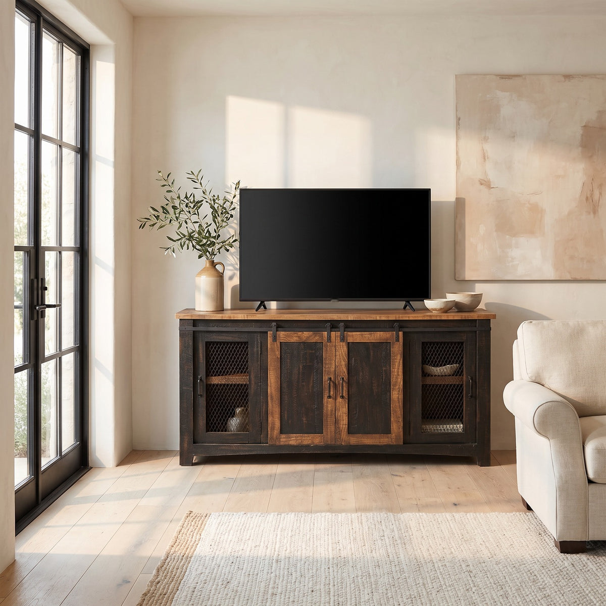 Barn door TV stand with a 65 inch TV in a sunlit farmhouse family room beside tall French doors