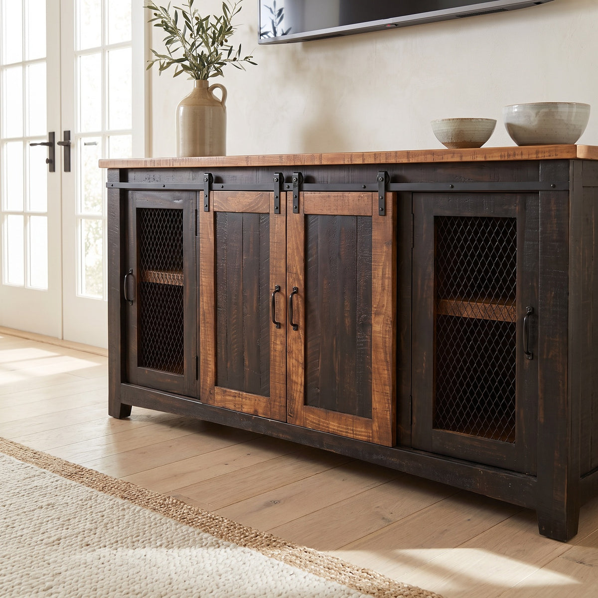 Close view of the barn door TV stand's sliding doors and mesh cabinets in a bright farmhouse living room