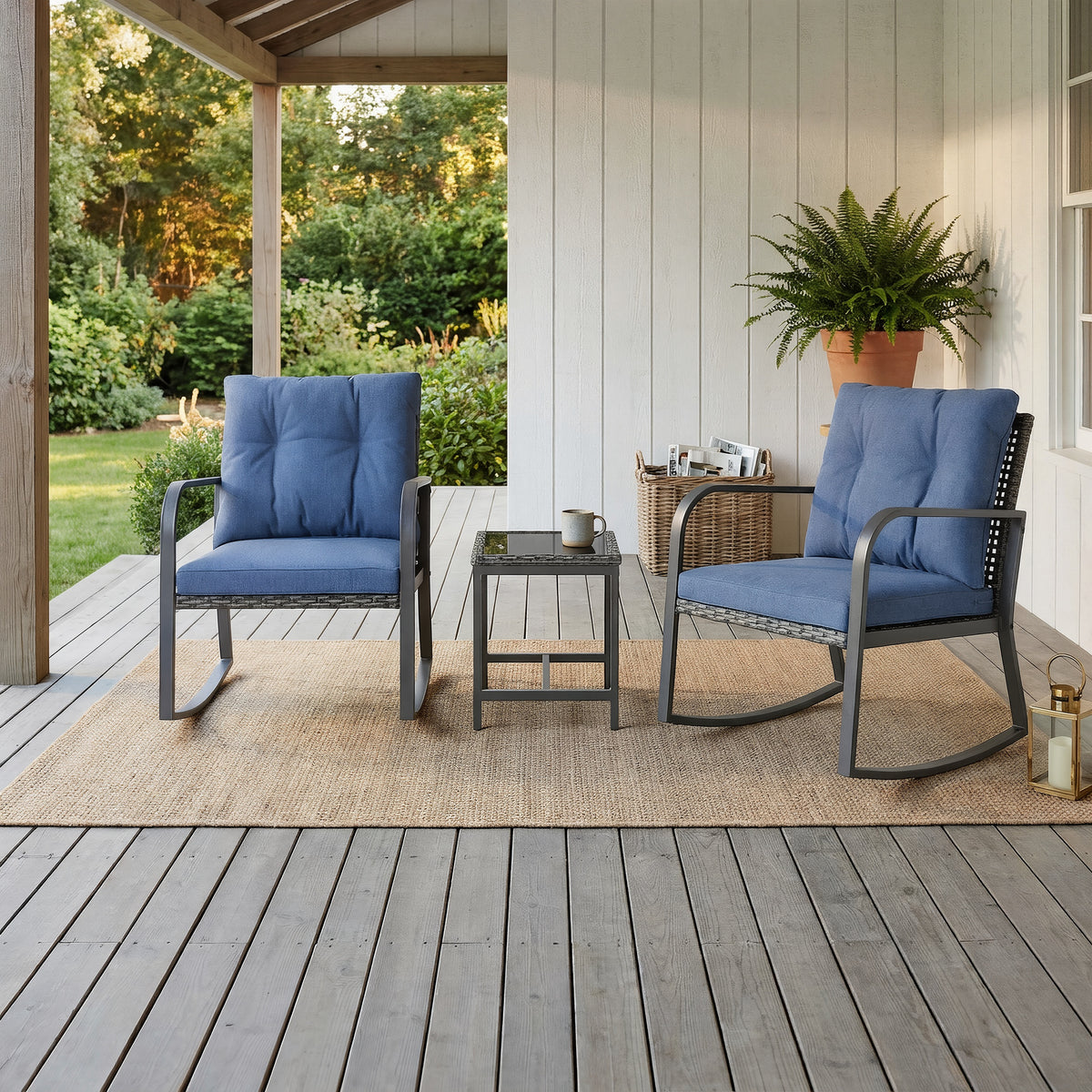 Covered veranda with two blue-cushioned rocking chairs and a glass-top side table on a sisal rug