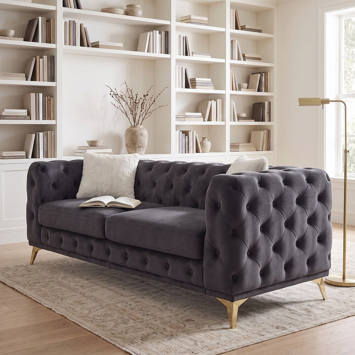 Black velvet tufted sofa seen closer from the window side in the same library, with an open book on the cushion
