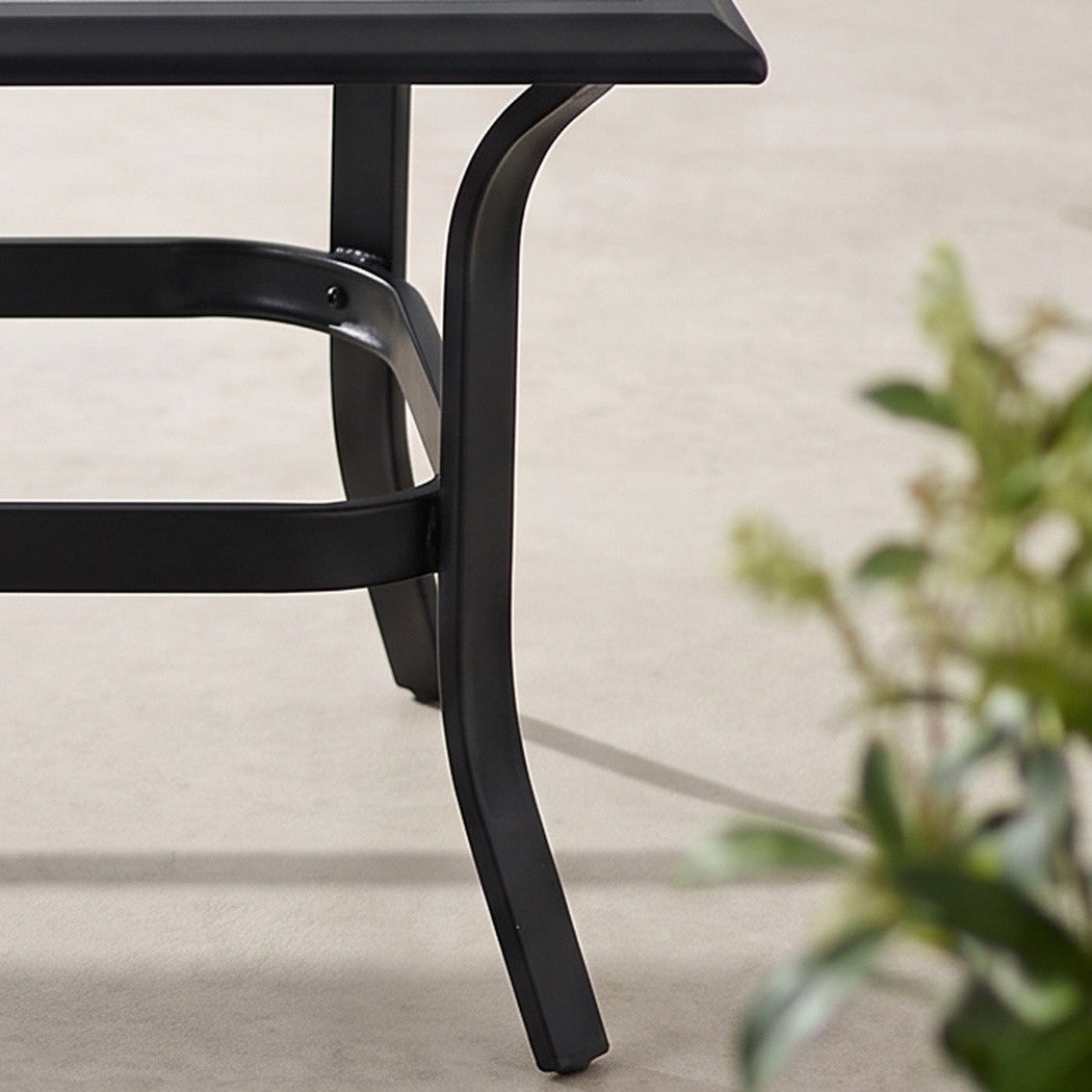 Close-up detail of the coffee table's rear leg on a patio