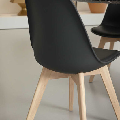 Mid-century modern black plastic-shell dining chair with natural wood legs, four-piece set.
