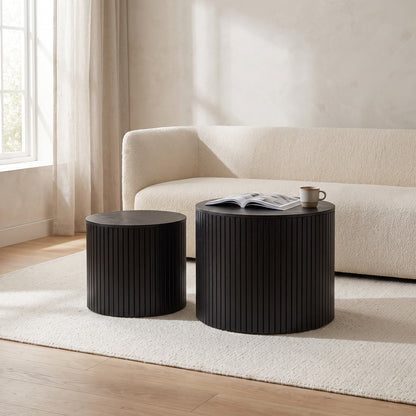 Black round nesting tables beside a cream sofa in a bright living room (room)