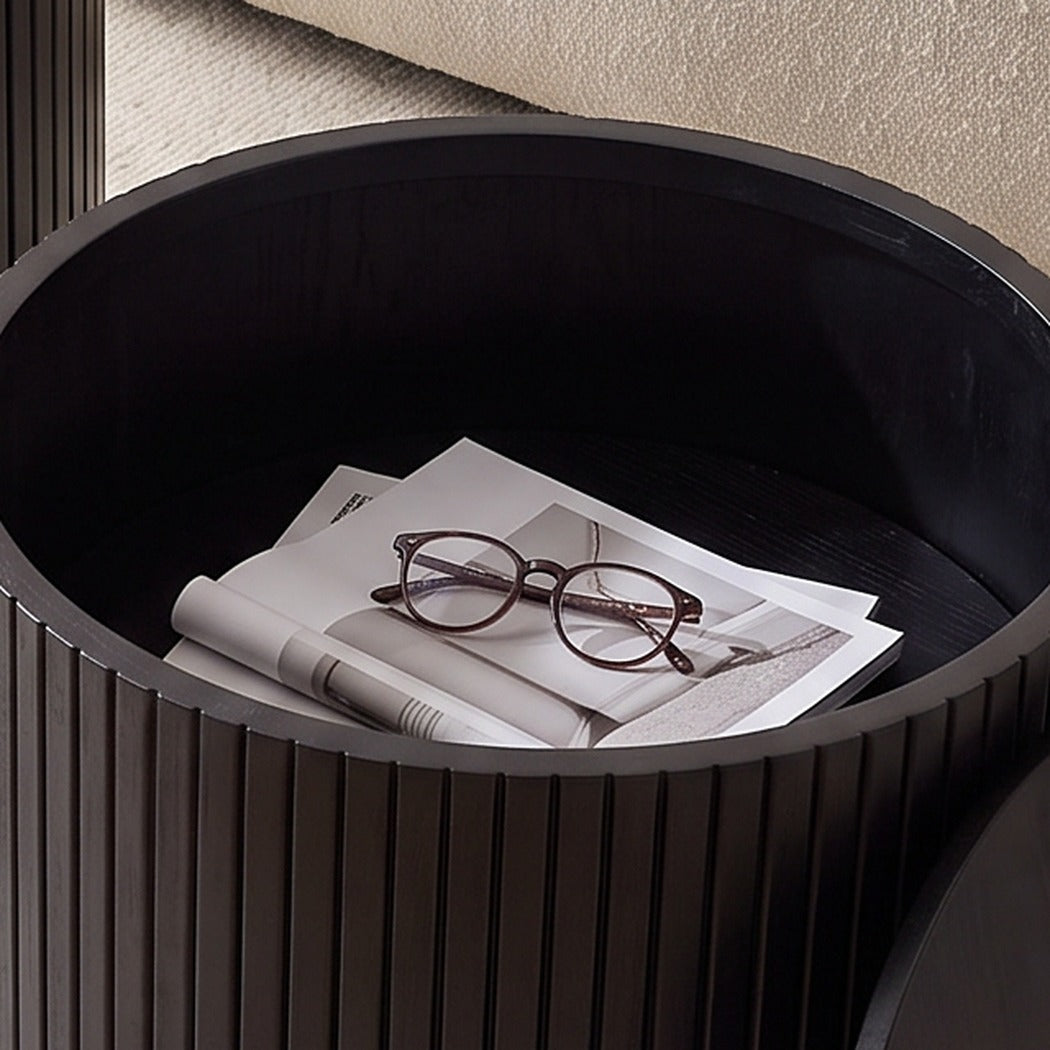 Open storage cavity inside the nesting table holding magazines and reading glasses (close-up detail)