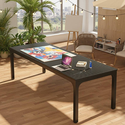 78-inch black rectangle dining table for 6–8 in a bright room with plants; laptop and art supplies on top.