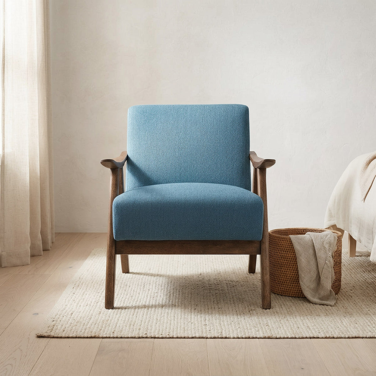 Blue linen accent chair front view on a jute rug in a bedroom