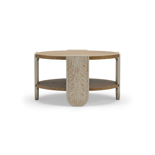 Round carved wood coffee table with oak top, lower shelf and cream carved legs, front view