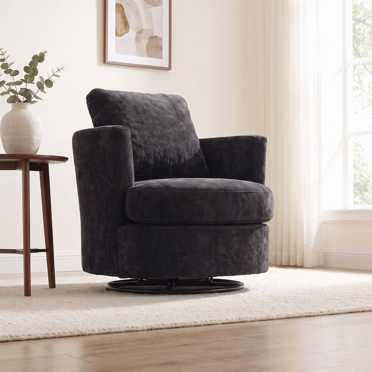 Black chenille swivel chair seen low from across the same living room